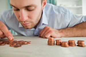 Young businessman counting coins